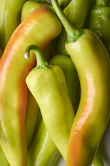pile of banana peppers in full frame, capsicum annuum, popular chili pepper that is long, curved shape with mild in heat and tangy and slightly sweet flavor, close-up view of food background
