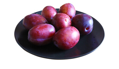 Fresh purple President plums on a black plate. Isolated fruit with transparent background.