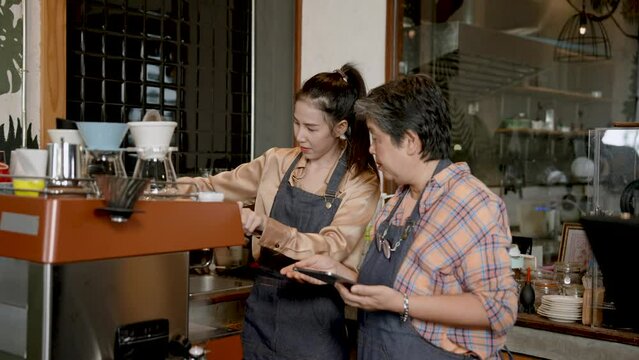 Waitress was waiting for customers orders was senior woman was mother barista owned cafe, they are standing talking telling orders as customers order, have good mood with customers throughout day.