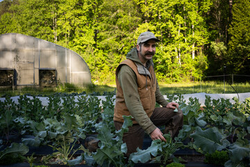 A young farmer hipster stands confidently in a lush green field, exuding a sense of connection to nature and a modern aesthetic. 