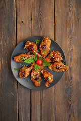 Marinated grilled healthy chicken breasts cooked on a summer BBQ and served with fresh herbs and lemon juice on a wooden board, close up view
