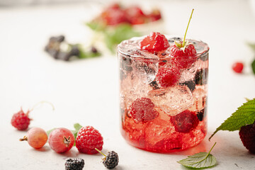 Glass of berry cocktail or drink soda with fresh berries on white background