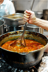 Chef cooking food at restaurant kitchen close up