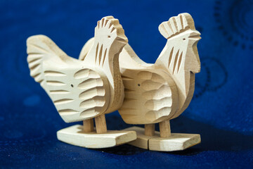 Two wooden chickens on blue