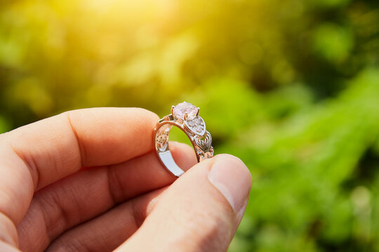 Zoom View Man's Hand Hold Pink Wedding Ring