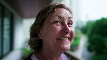 A joyful relaxed senior lady looking up at sky smiling. One pensive older 70s female person in...