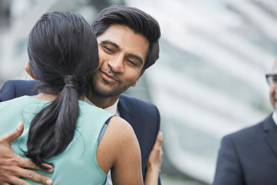 Businesspeople greeting each other with kiss on cheek