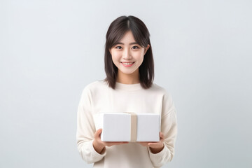 Fototapeta premium In front of view portrait of woman wearing T-shirt standing with carton box and looking at camera with sweet smile isolated on white gray background. Generative AI.