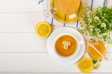 Chamomile tea on a white table. Delicious tonic, soothing and relaxing chamomile tea with chamomile...