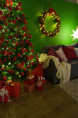 Christmas living room interior with sofa, Christmas tree and wreath on green background