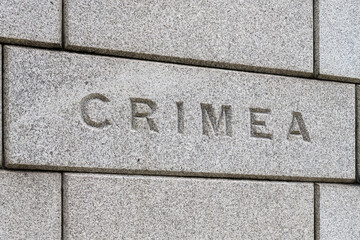 Word Crimea carved on brick