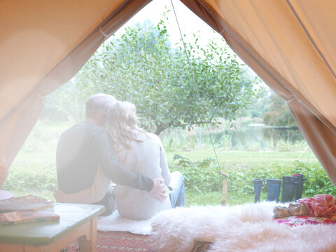 Mature married couple sitting in tent together.