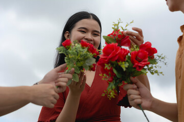 A young asian woman receives flowers by two separate men competing for her love. A popular lady in college.