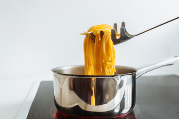 man cooks pasta spaghetti at home in kitchen.