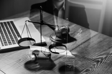 Justice and law concept.Male judge in a courtroom with the gavel, working with, computer and docking keyboard, eyeglasses, on table in morning light