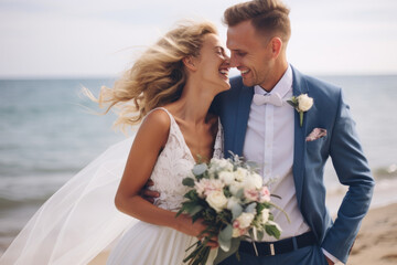 The bride and groom laugh and walk on the seashore