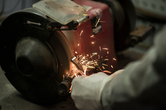 Hand of mechanic grinding metal