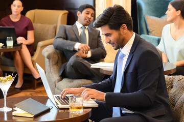 Businessman working on laptop at bar