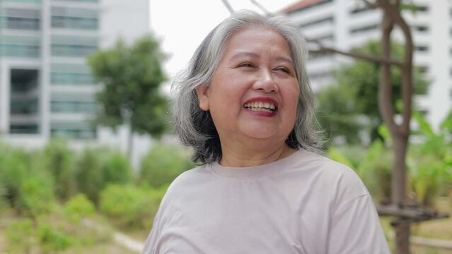 Portrait of happy smiling Asian elderly woman exercising in rooftop garden in morning time. Sport concept. Exercise for the health of the elderly.