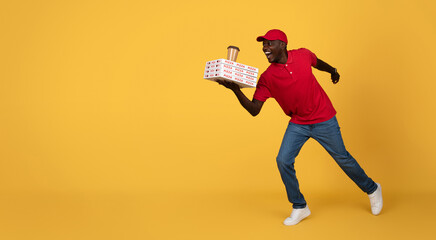 Glad young african american delivery man in uniform run with many pizza boxes, cup of coffee takeaway