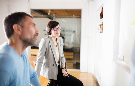 Businesswoman With Glasses Talking To Colleague In Office