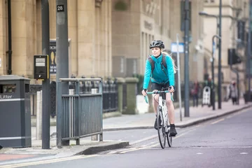 Keuken spatwand met foto Woman commuting by bicycle on city street © Image Source