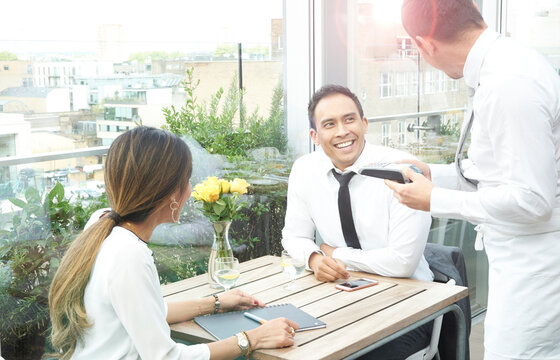Businesspeople with EFTPOS machine in restaurant