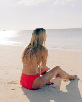 Topless woman sitting on beach