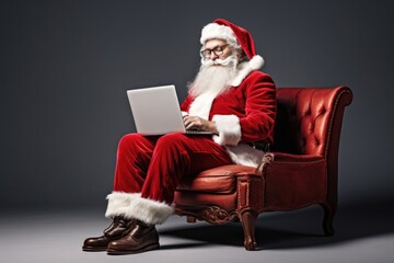 Happy old Santa Claus wearing costume on North Pole using laptop computer sitting at workshop table on Merry Christmas eve. Ecommerce website xmas time holiday online shopping sale concept. 