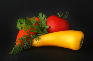 Fresh vegetables on a black background. Pepper, tomato and parsley