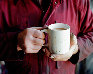 Man's hand holding cup of tea