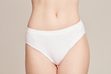 Groin of young woman wearing white underwear