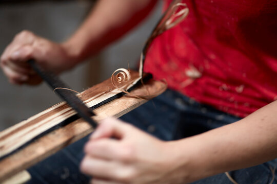 Hands of woman shaving wood