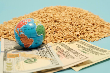 Deal grain concept. American 100 dollars, a small globe next to a scattered grain of wheat. The economic crisis during the hostilities. The threat of hunger.