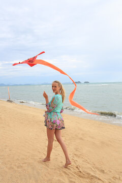 Young woman flying kite on beach