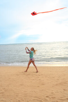 Young woman flying kite on beach
