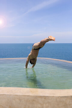 Young man diving into swimming pool