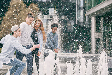 Teenagers playing with water fountain