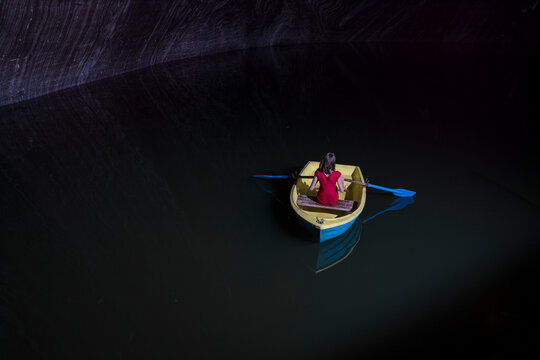Young woman in rowboat on lake