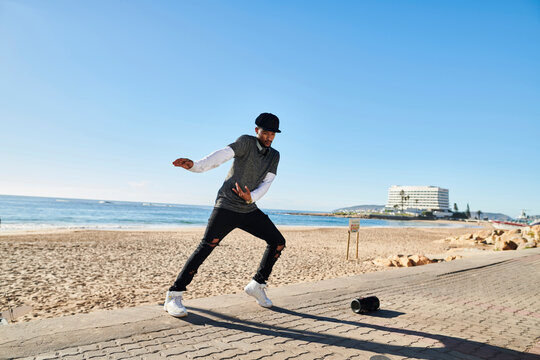 Young man break dancing by beach