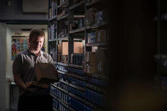 Mechanic gathering parts from shelf