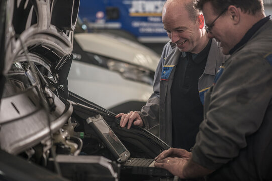 Colleagues working together at mechanic workshop
