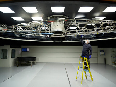 Man on ladder inspecting telescope at Paranal Observatory