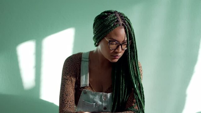 Contemplative African American young woman with braided hairstyle. One pensive black adult girl with box braids style. Thoughtful emotion