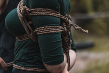 tied up woman in green body and black tights with a natural rope japanese art of aeshetic shibari bandage kinbaku
