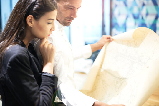 Colleagues examining blueprint