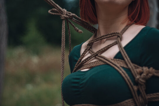 breast of beautiful redhead woman in green body tied with shibari rope Kinbaku japanese bandage
