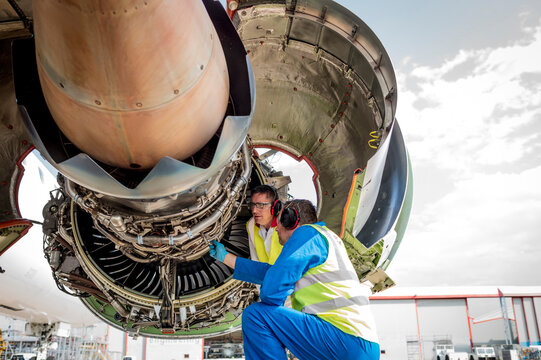 Men working on airplane engine
