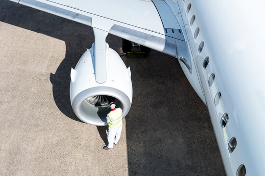 High angle view of man working on airplane engine