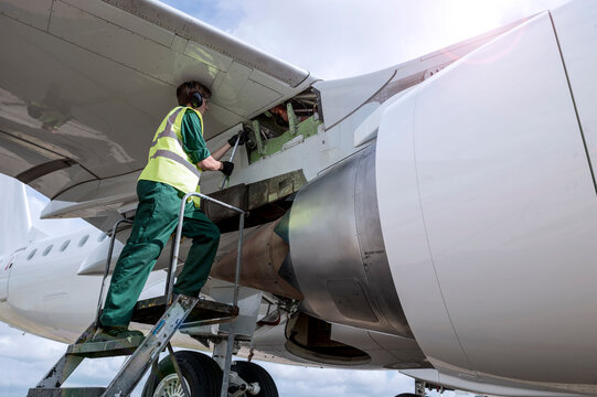 Man working on airplane wing